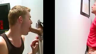 Gay twinks sucks on a muscular guy's big cock through a gloryhole