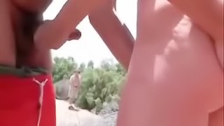 Big-assed chick and a stranger touch each other's privates on a beach